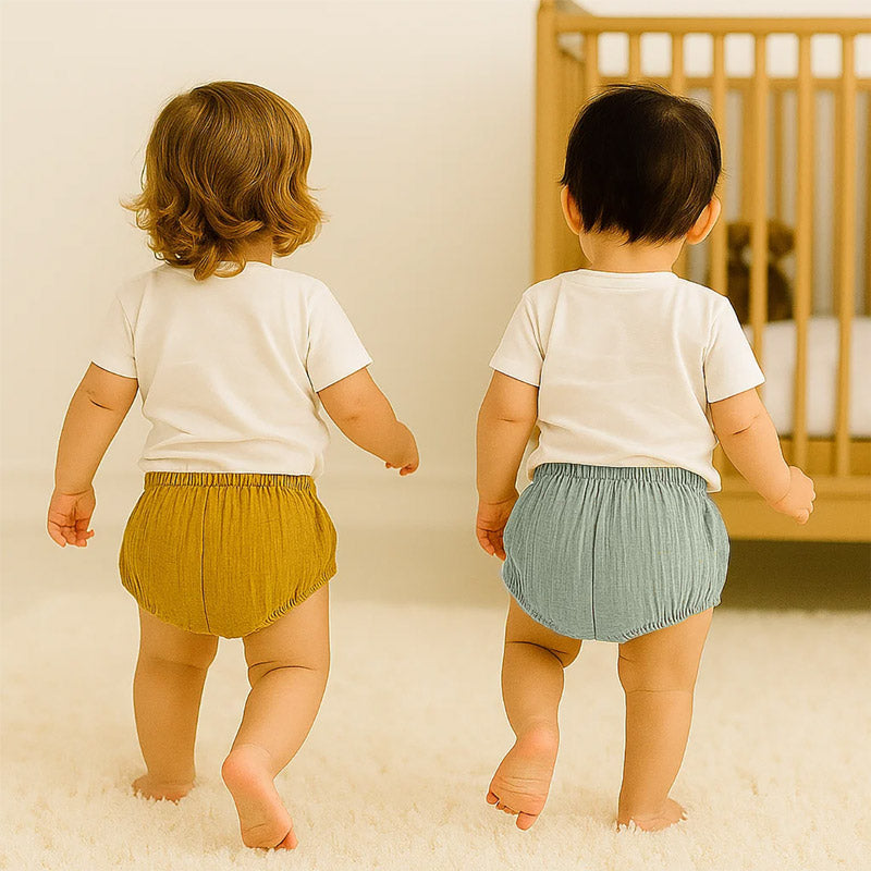 To bloomers i økologisk bomuld i grøn og honningfarvet – bløde og rummelige babyshorts fremstillet i Frankrig.