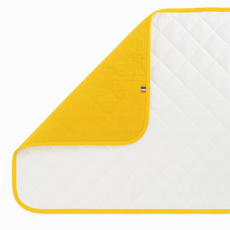 Pusleunderlag i økologisk bomuld – sammenklappeligt og vandafvisende med blød polstring, perfekt til skift hjemme og på farten.