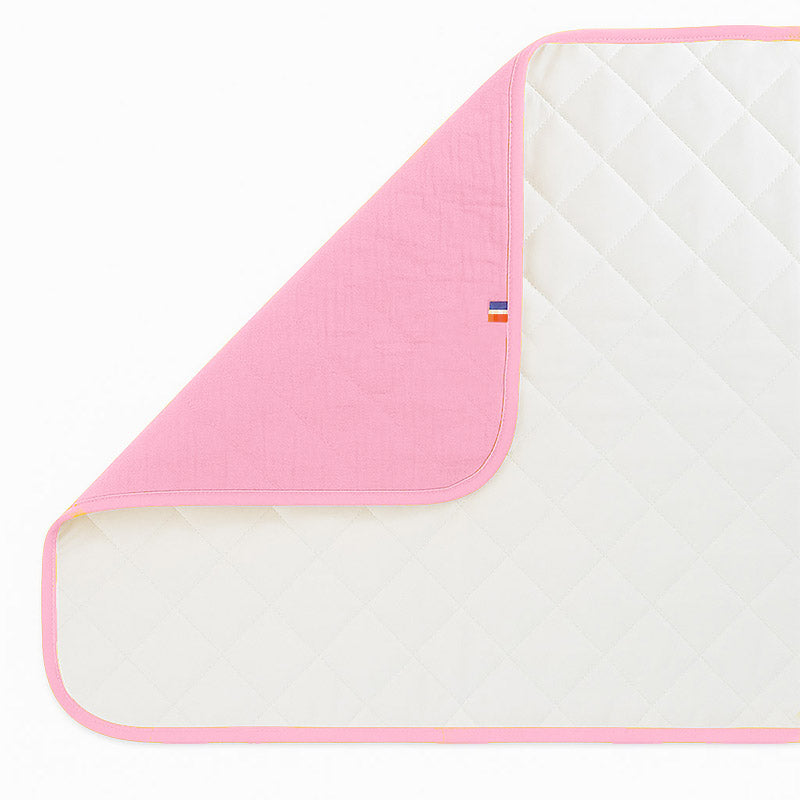 Pusleunderlag i økologisk bomuld – sammenklappeligt og vandafvisende med blød polstring, perfekt til skift hjemme og på farten.